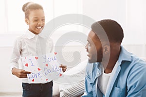 Daughter congratulating dad with father`s day at home