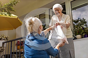 Daughter delivering groceries to her elderly mother