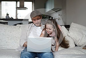 Daughter disturbing stressed father in living room. Working from home during quarantine.