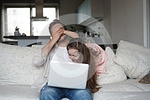 Daughter disturbing stressed father in living room. Working from home during quarantine.