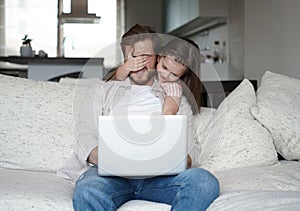 Daughter disturbing stressed father in living room. Working from home during quarantine.