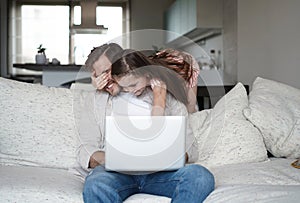 Daughter disturbing stressed father in living room. Working from home during quarantine.