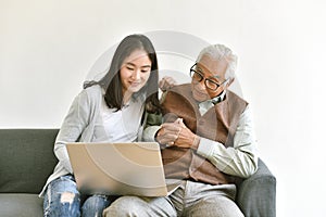 Daughter and elderly father using laptop computer together, Senior people spend time learning to use social media and digital. photo