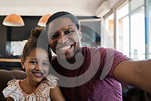 Daughter and father taking a selfie at home. photo