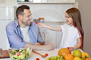 Daughter Feeding Daddy Having Fun Cooking Together In Modern Kitchen