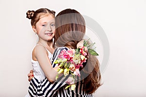 Daughter gives flowers to her mother on her mother`s day