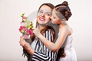 Daughter gives flowers to her mother on her mother`s day