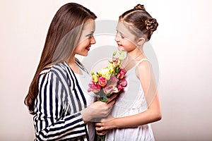 Daughter gives her mother flowers in the studio, happy mother`s