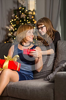 Daughter giving Christmas present to mother at home
