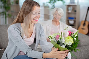 daughter giving flowers to mom
