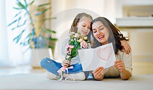 Daughter giving mother bouquet of flowers