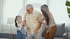 Daughter and granddaughter take care support grandfather who is suffering from knee pain Got walking