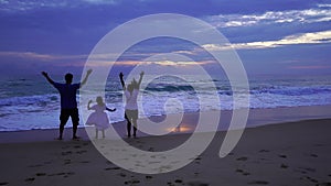 Daughter holding hands of dad and mom on the beach running on sandy shore at sunset Amazing light sunset or sunrise sky watching s