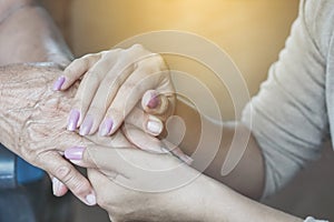 Daughter holding her mother`s hand and comforting