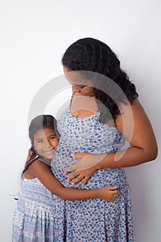 daughter hugging her pregnant mother.