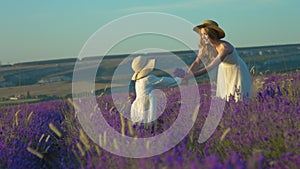 Daughter and mom send each other air kisses in the flowering field of lavender