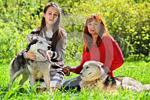 Daughter and mother along with two dogs in park on
