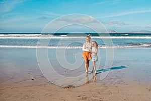 Daughter with mother with broken arm on beach. Arm cast, injured during family vacation in holiday resort. Concept of