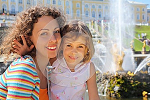 Daughter with mother near fountains of Petergof