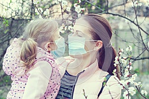 Daughter and mother wearing masks on the street