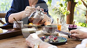 Daughter pouring hot tea for mother