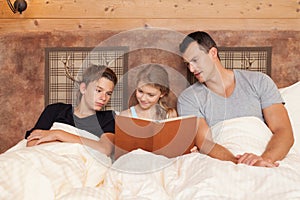 Daughter reading book to brother and father - happy family