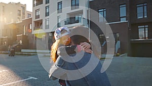 Daughter runs to dad and hugs him. Father picks up the child in his arms and circles her. Slow motion