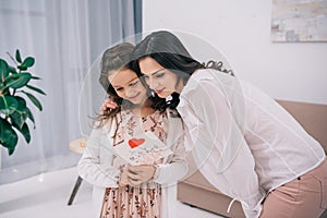 daughter showing greeting card to mother mothers