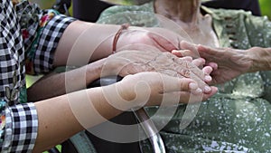 Daughter take care elderly mother on wheelchair at home