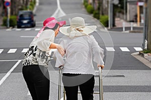 Daughter take care elderly woman walking on street