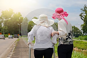 Daughter take care elderly woman walking on street