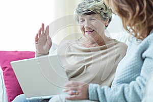 Daughter teaching mum using laptop