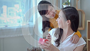 The daughter of a teenager is giving a gift to the mother on the special occasion of her mother