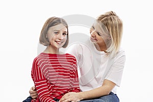 Daughter teenager and mother laugh and hug. Love and support in family relationships. White background. Space for text