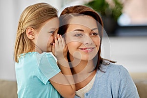 Daughter whispering secret to mother at home