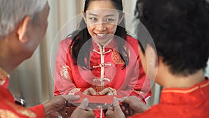 Daugther give red envelop to father mother in Chiense New Year