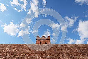 a daunting high brick wall under a clear sky