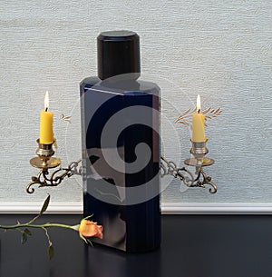 Davidoff Cool Water, Eau de Toilette, large perfume bottle in front of a andelabra with shining candles decorated with a rose