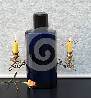 Davidoff Cool Water, large perfume bottle in front of a piano candelabra with shining candles decorated with an English rose