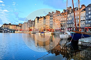 Dawn at Honfleur harbor with boats and reflections, France