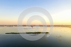 Dawn at the industrial city with a port and an island in the foreground. Drone photography