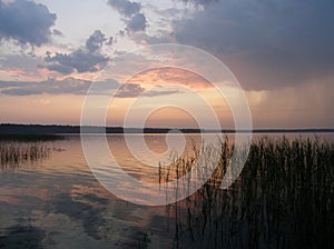 Dawn on the lake. Rain clouds. It`s raining on the horizon