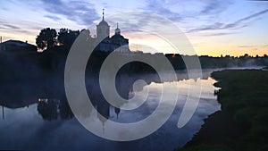 Dawn mist on the river near the church on the cliff high cliffs nature. Ural village of Sloboda.