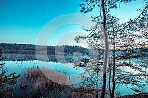 Dawn over the lake with the rocky shore