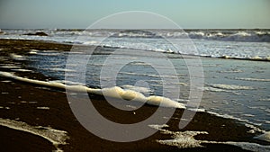 Foam on the sand on the extensive beach photo