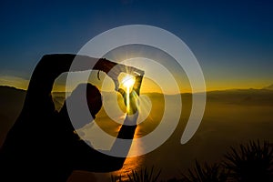 Dawn views of Lake Atitlan and hiker doing shapes from the heights of Indian Nose pointview