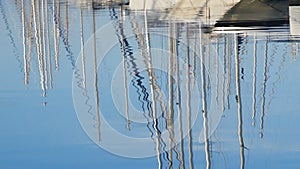 At dawn, in the water reflect the masts of white chic beautiful yachts. Clear summer morning in the marina, on the sea