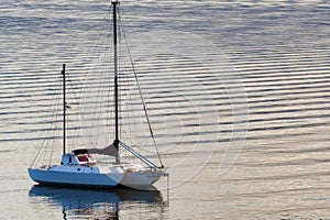 Dawns light reflect boat and rippled waters