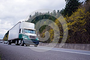 Day cab semi truck with aerodynamic spoiler and trailer on highw photo