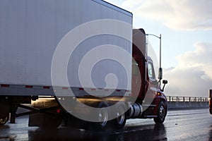 Day cab semi truck trailer in rain and sun reflection
